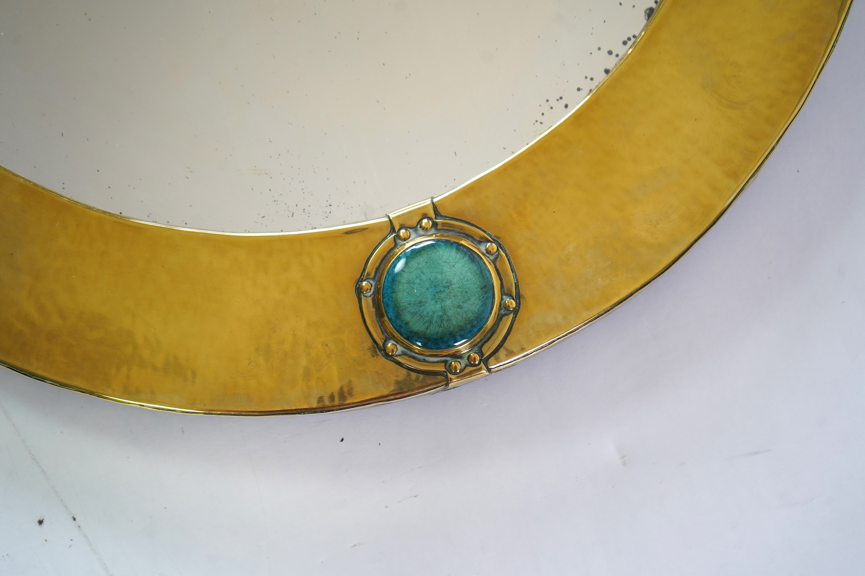 Liberty & Co.: An Arts And Crafts brass and Ruskin pottery cabochon mounted mirror